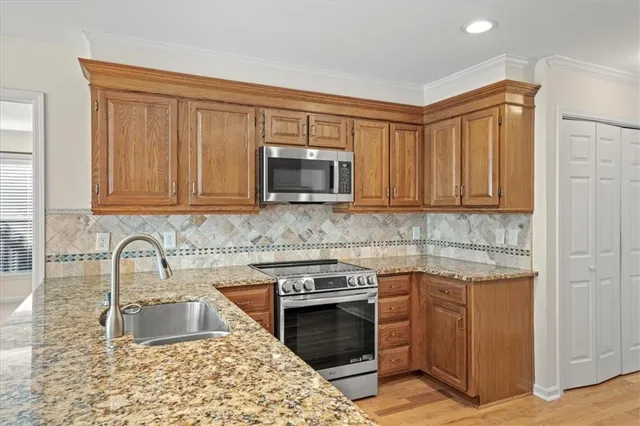 a kitchen with granite countertop a sink stove and microwave