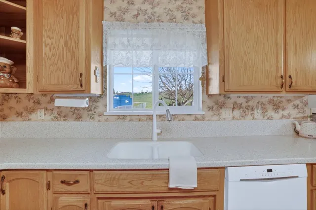 a kitchen with stainless steel appliances granite countertop a dining table chairs and a refrigerator