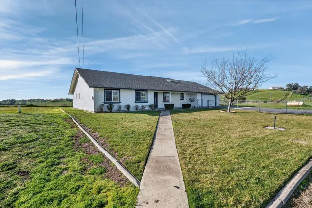 a view of a house with swimming pool and a yard