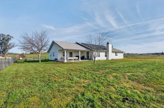 a view of a house with backyard and porch
