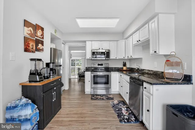 a kitchen with granite countertop a stove top oven and cabinets