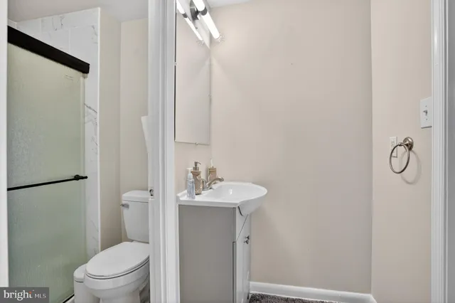 a bathroom with a granite countertop sink toilet and a mirror
