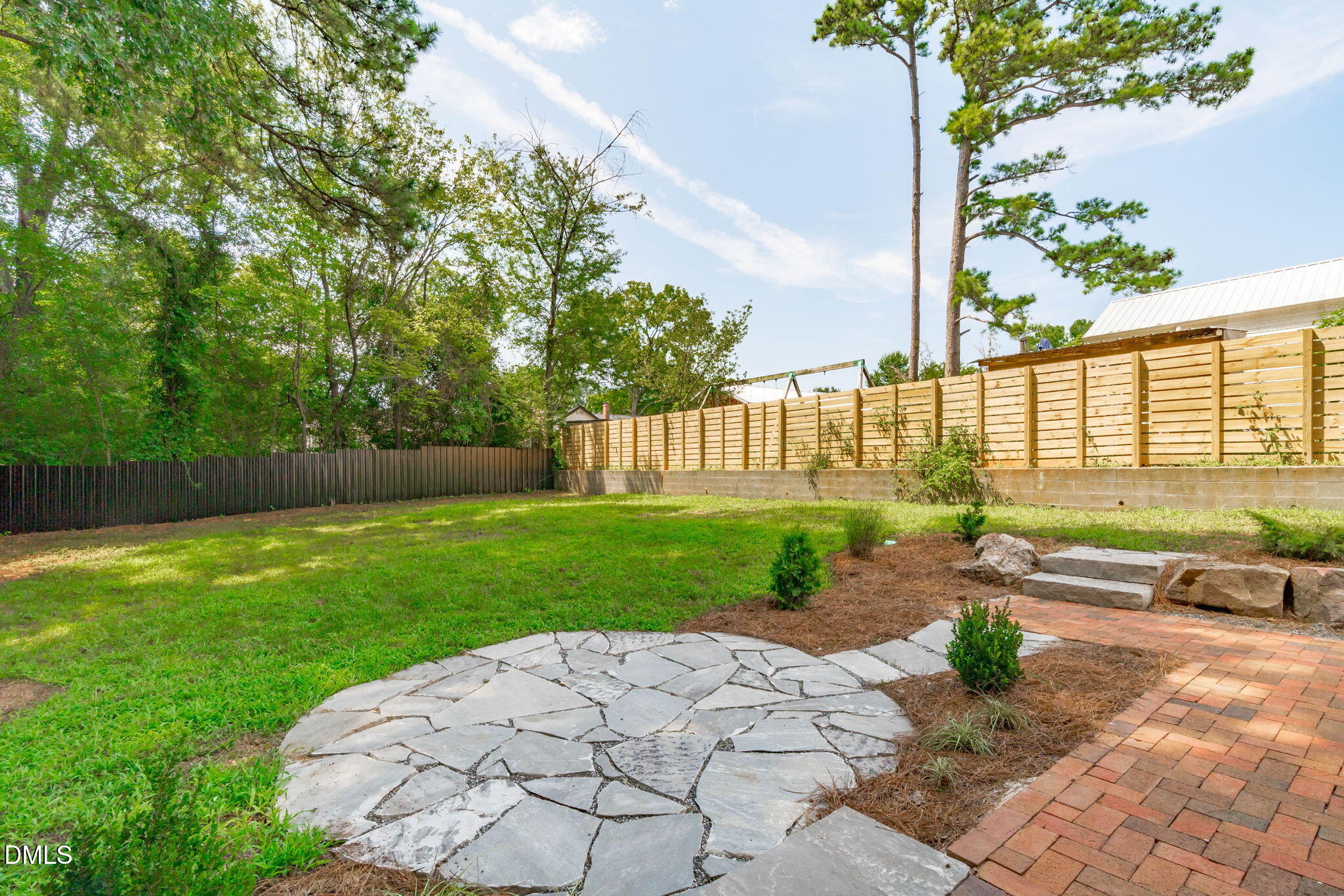728 Brighton Road Raleigh, NC 27610 - Photo 35 of 38 Wooden slat privacy fence on neighbor side with metal along the back.