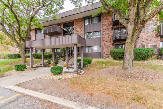a view of a brick house with a large windows and a large tree
