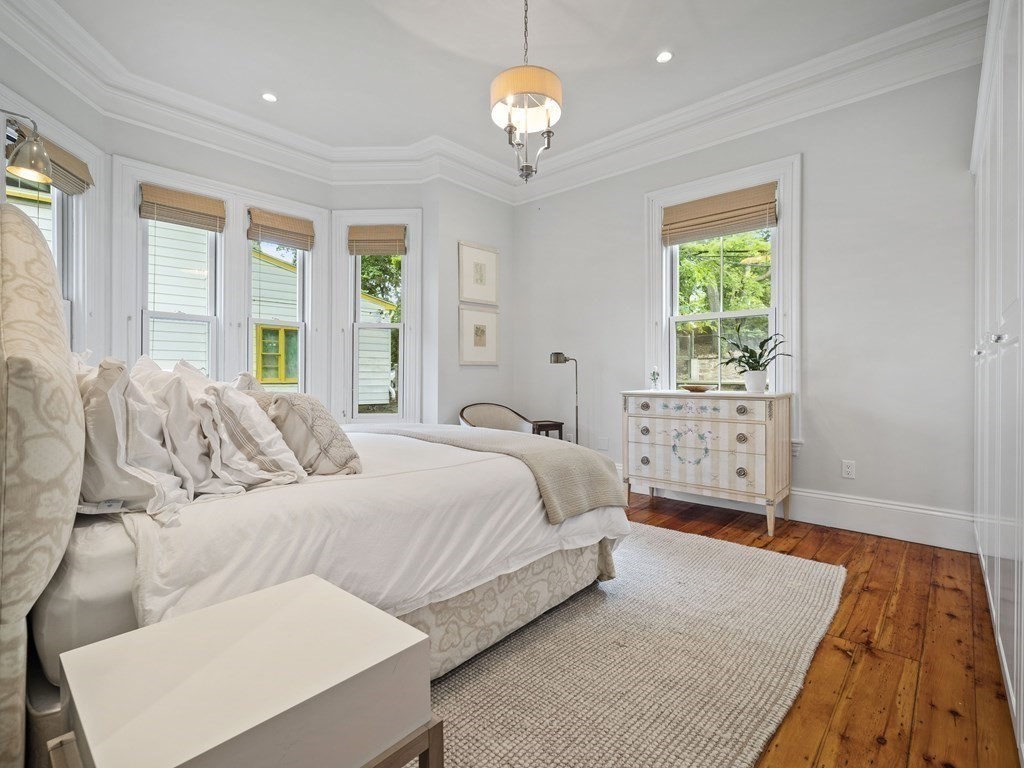 99 Sedgwick Street, Unit 1 Boston, MA 02130 - Photo 20 of 41 a bedroom with a bed and a chandelier