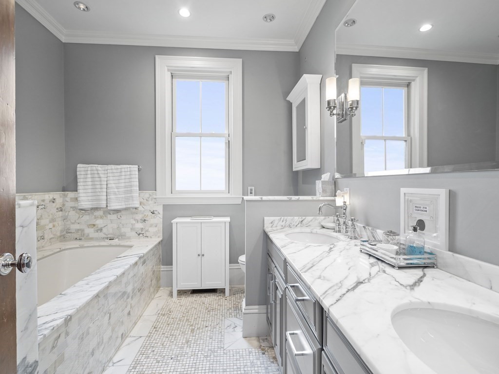 99 Sedgwick Street, Unit 1 Boston, MA 02130 - Photo 22 of 41 a bathroom with a granite countertop sink double vanity and mirror