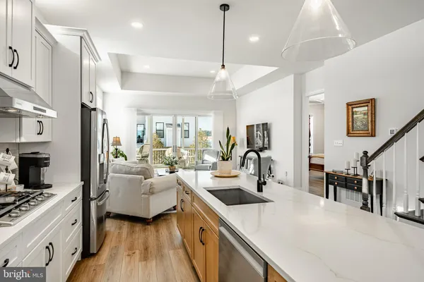 a kitchen with kitchen island a large counter top space a sink stainless steel appliances and cabinets