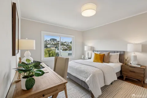 a bedroom with a bed and a large window