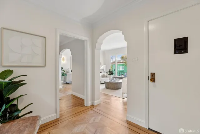 a view of a hallway with wooden floor and a living room