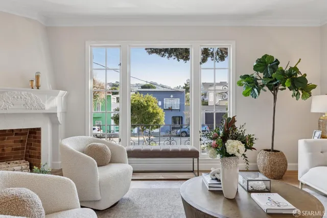 a living room with furniture fireplace and a large window