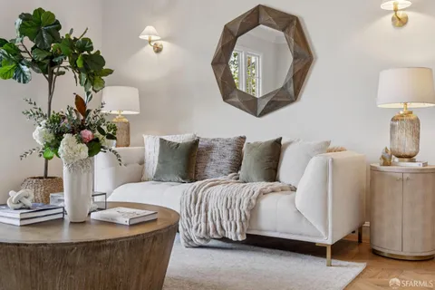 a living room with furniture flowerpot and a mirror