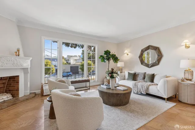 a living room with furniture a fireplace and a large window