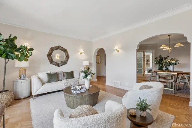 a living room with furniture potted plant and white walls