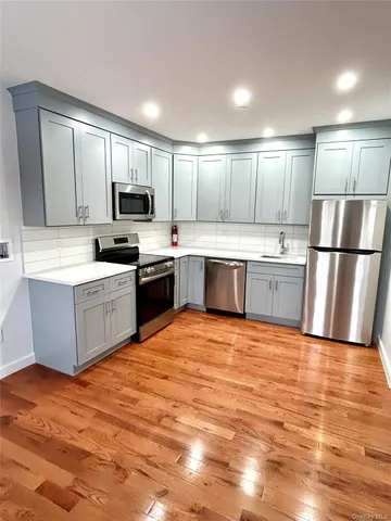 a large kitchen with cabinets and stainless steel appliances