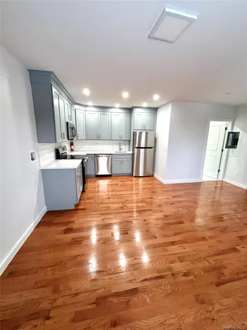 a view of a kitchen with kitchen island a sink wooden floor and a counter top space