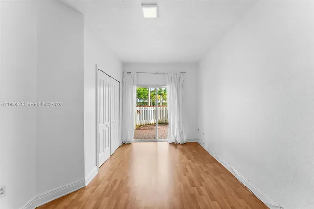 a view of a room with wooden floor and window