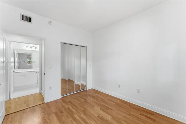 a view of a livingroom with wooden floor and a bathroom