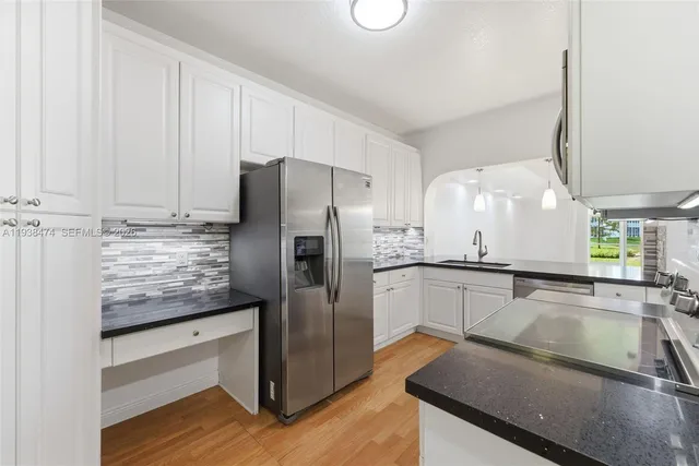 a kitchen with stainless steel appliances granite countertop a sink refrigerator and microwave