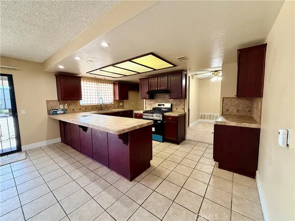 a kitchen with stainless steel appliances granite countertop a stove a sink and a microwave