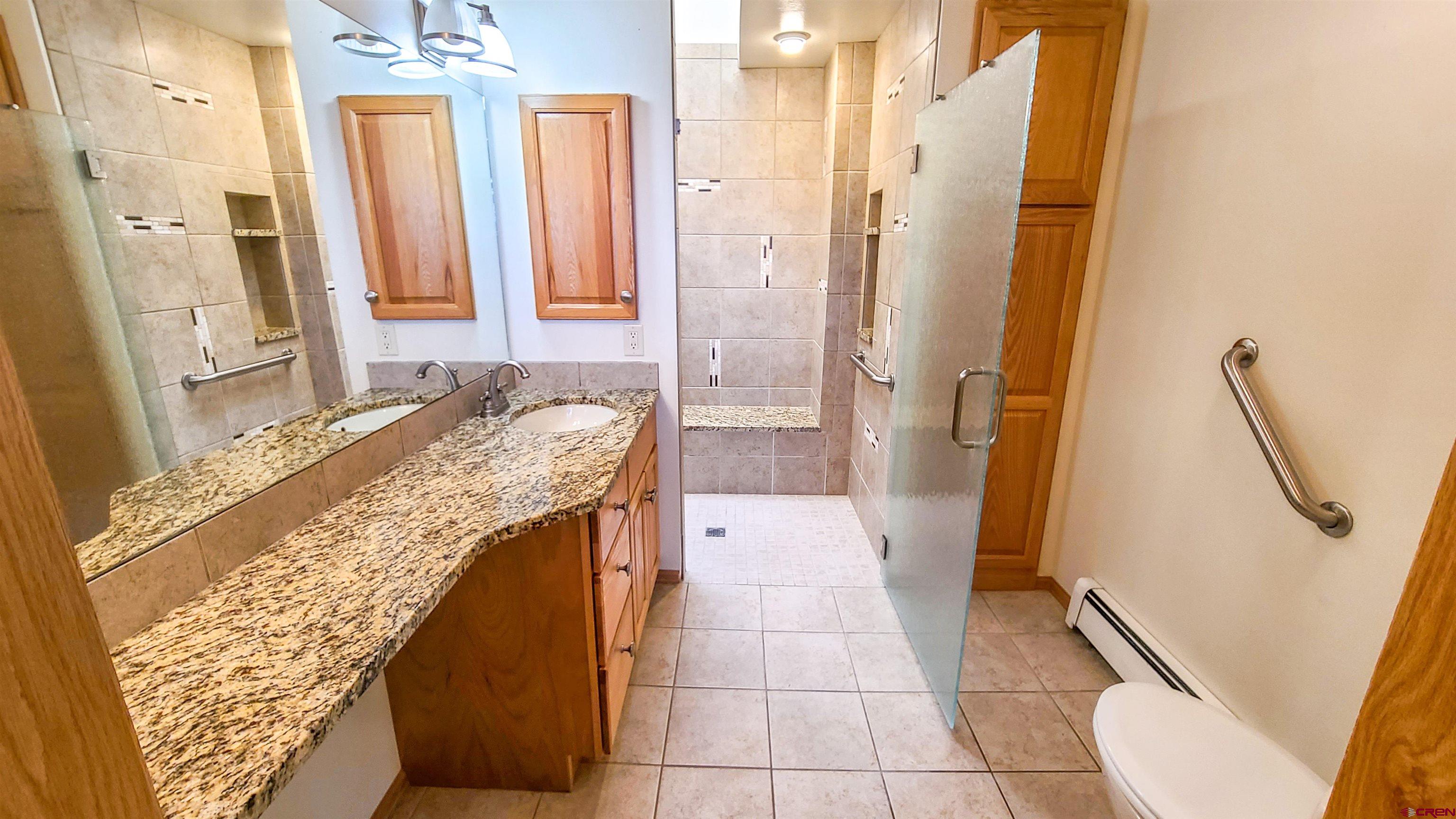 2916 East 7/8 Road Grand Junction, CO 81504 - Photo 17 of 35 a bathroom with a granite countertop sink and a mirror