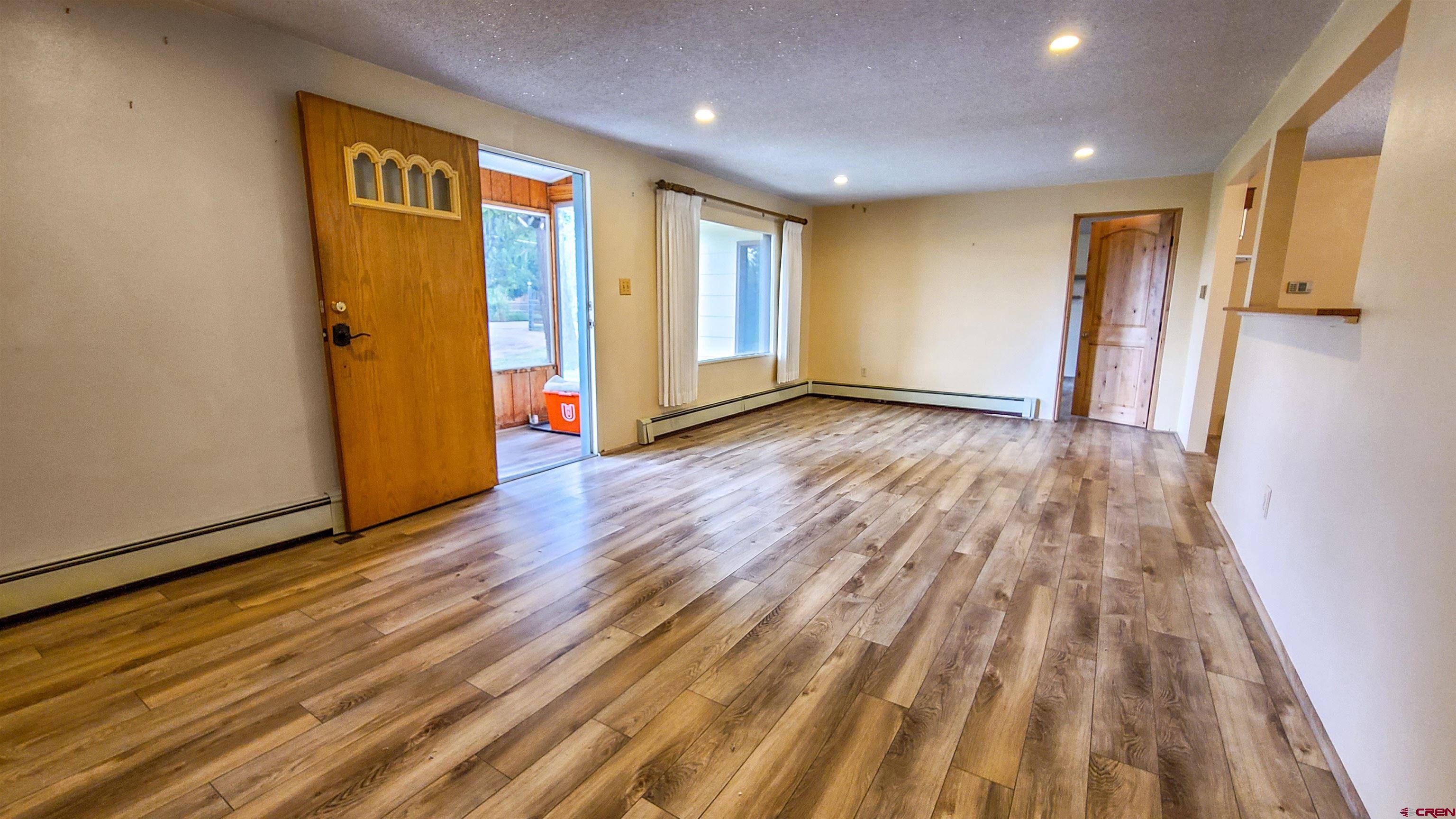2916 East 7/8 Road Grand Junction, CO 81504 - Photo 7 of 35 a view of an empty room with wooden floor and a window