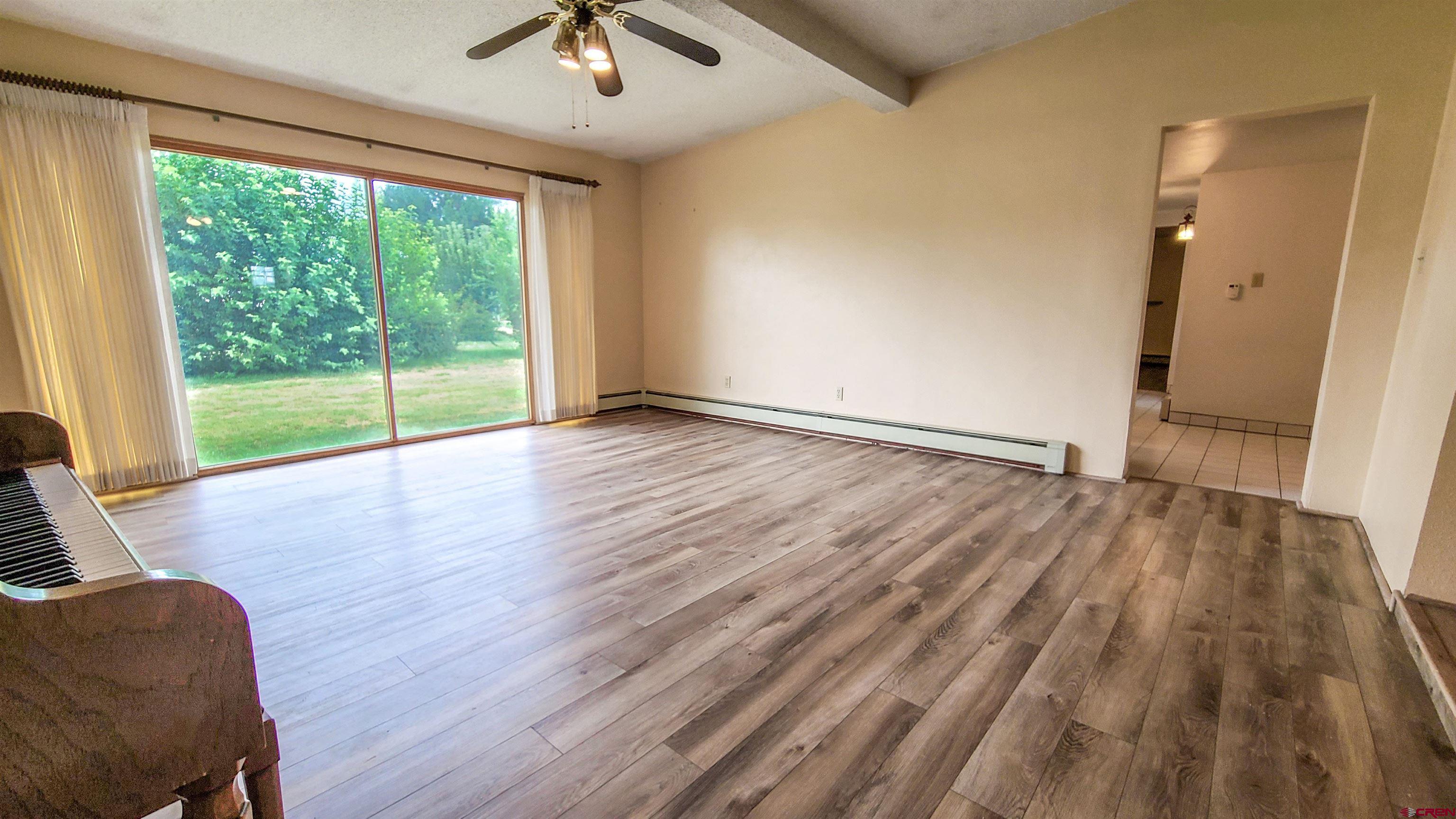 2916 East 7/8 Road Grand Junction, CO 81504 - Photo 9 of 35 a view of room with hardwood floor and a ceiling fan