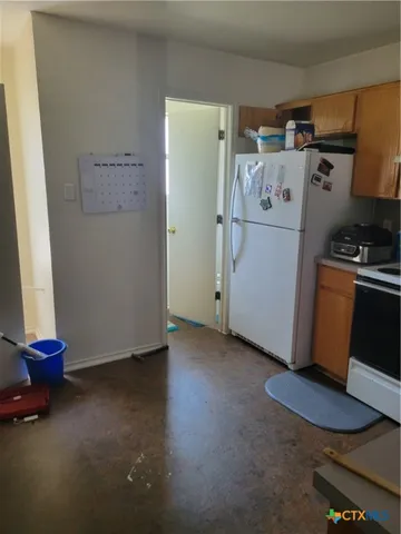 a view of kitchen with refrigerator and stove