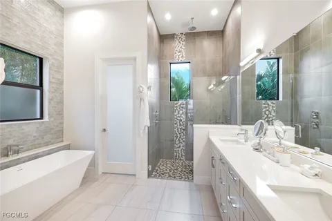 a bathroom with a tub sink and mirror
