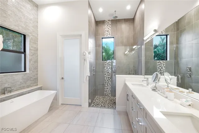 a bathroom with a tub sink and mirror