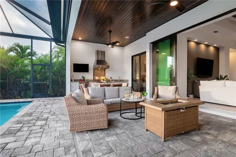 a living room with patio furniture and a fireplace