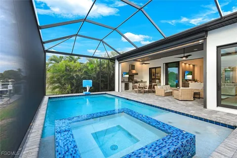 a view of swimming pool with seating area and trees in the background