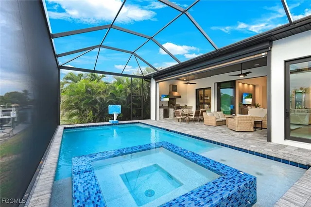 a view of swimming pool with seating area and trees in the background