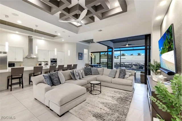 a living room with furniture flat screen tv and a chandelier