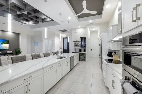 a large white kitchen with stainless steel appliances