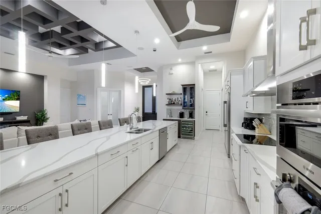 a large white kitchen with stainless steel appliances