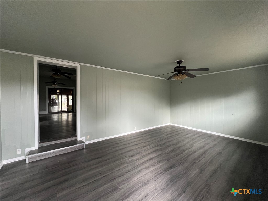 607 North Cleveland Street Victoria, TX 77901 - Photo 4 of 9 an empty room with wooden floor and windows