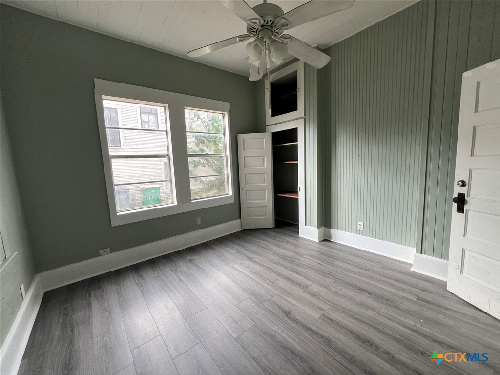 607 North Cleveland Street Victoria, TX 77901 - Photo 5 of 9 an empty room with wooden floor chandelier fan and windows