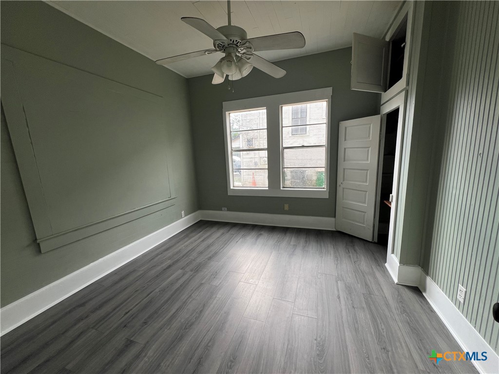 607 North Cleveland Street Victoria, TX 77901 - Photo 6 of 9 an empty room with wooden floor fan and windows
