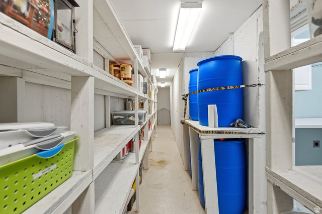 672 Perry Hollow Drive Mapleton, UT 84664 - Photo 79 of 106 Extensive utility space featuring full-height storage shelving, bright overhead fluorescent lighting, and concrete walls