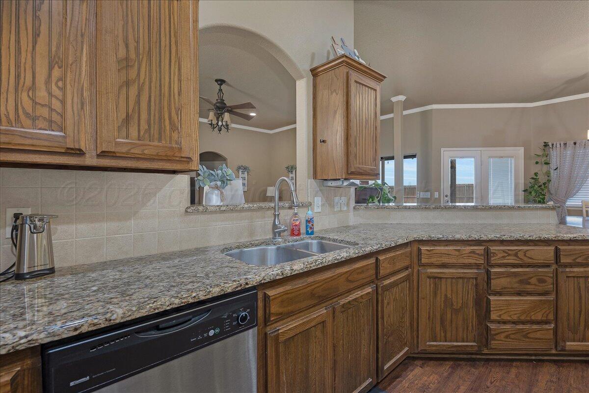 4801 Cedar Springs Trail Amarillo, TX 79119 - Photo 13 of 41 a kitchen with granite countertop a sink stainless steel appliances wooden floor and counter space