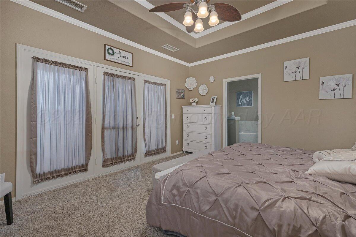 4801 Cedar Springs Trail Amarillo, TX 79119 - Photo 16 of 41 a bedroom with a large bed and a chandelier