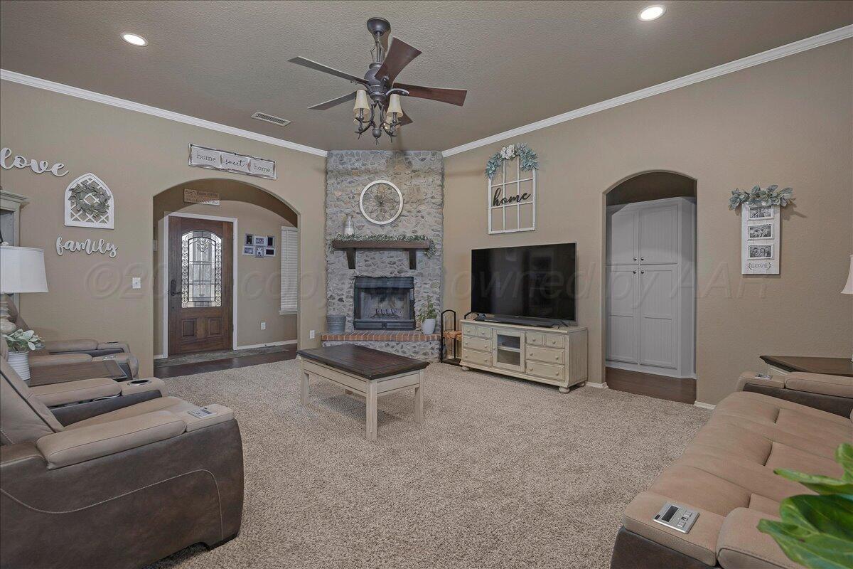 4801 Cedar Springs Trail Amarillo, TX 79119 - Photo 5 of 41 a living room with furniture a flat screen tv and a fireplace