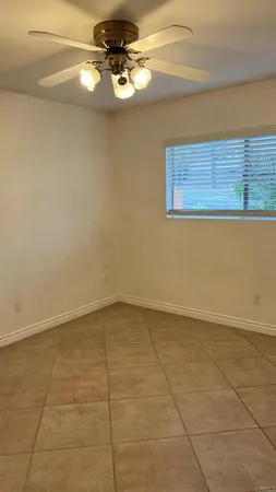 a view of a room with a ceiling fan and window