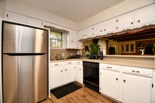 a kitchen with stainless steel appliances a refrigerator sink and cabinets