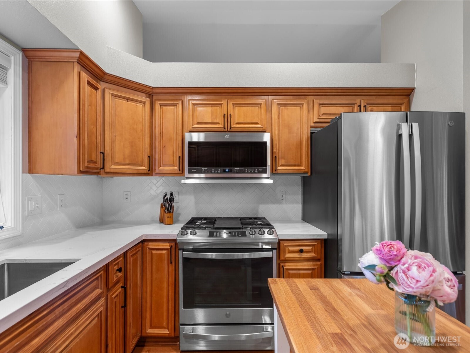 3218 189th Street Southeast Bothell, WA 98012 - Photo 11 of 40 a kitchen with stainless steel appliances a stove a microwave and a refrigerator
