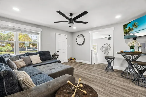 a living room with furniture a clock potted plant and a window