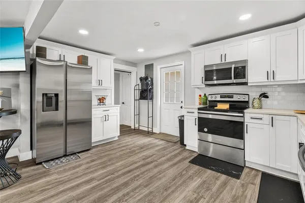 a kitchen with stainless steel appliances and wooden floor