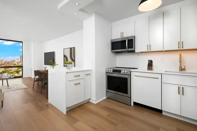 a kitchen with stainless steel appliances a stove microwave and sink