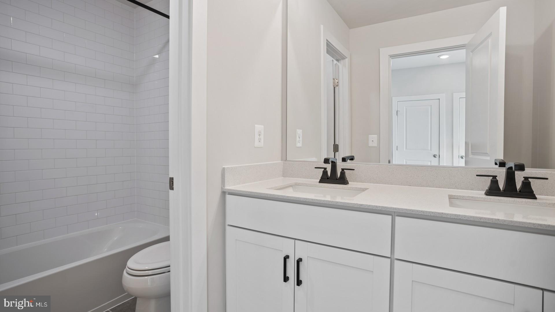 45176 Drowes Terrace Sterling, VA 20166 - Photo 12 of 15 a bathroom with a sink a toilet and a large mirror