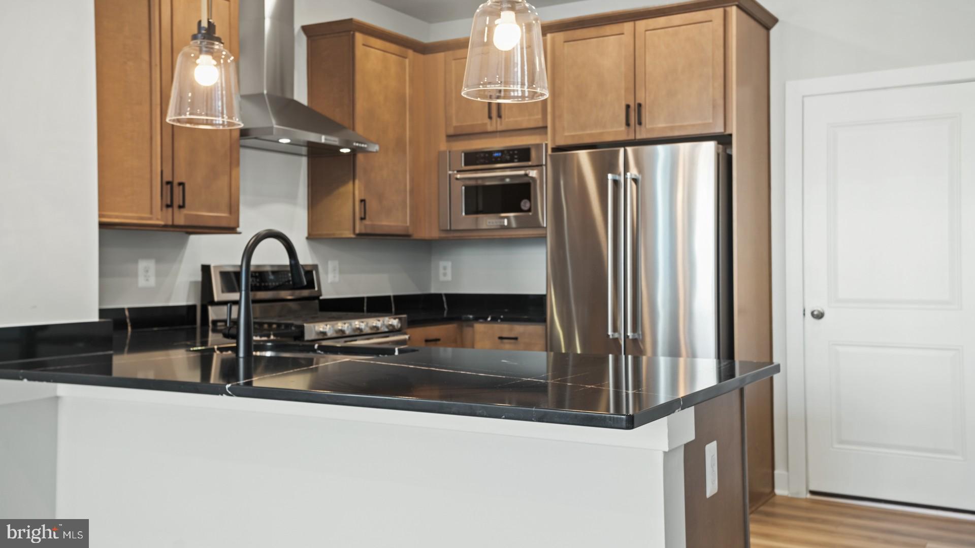 45176 Drowes Terrace Sterling, VA 20166 - Photo 3 of 15 a kitchen with granite countertop a refrigerator and a sink